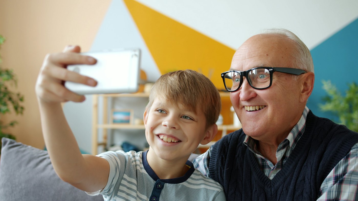 Un abuelo y su nieto se toman una foto con el celular