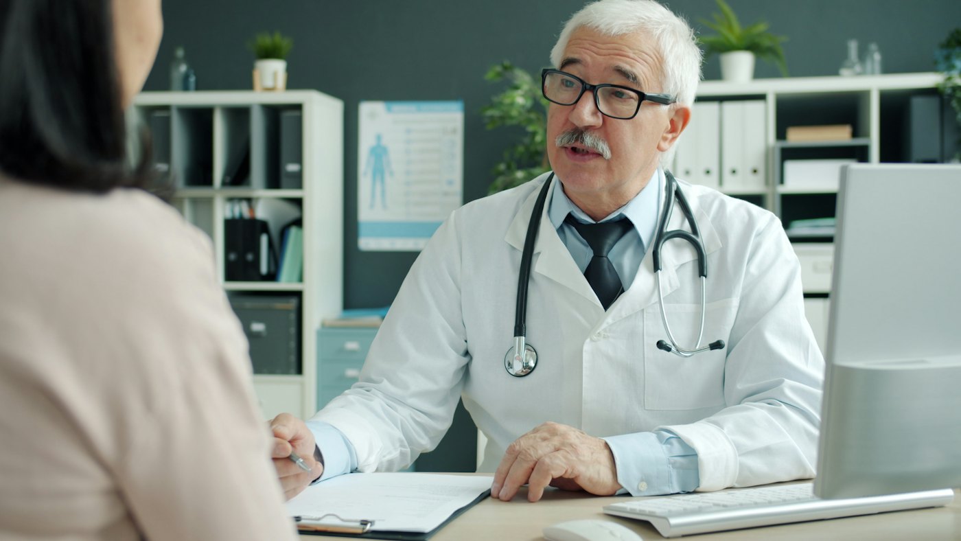 Un médico conversa con una paciente en el consultorio
